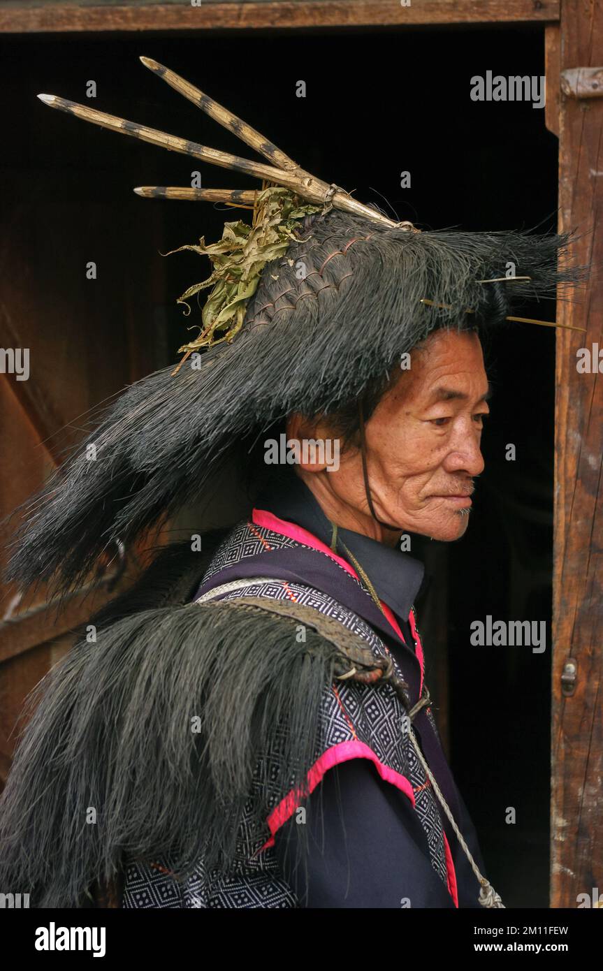 Ziro, Arunachal Pradesh, Indien - 03 05 2014 : Profilporträt eines alten Apatani-Stammesschamanen mit traditionellem rituellem Hut mit Hörnern auf dunklem Hintergrund Stockfoto