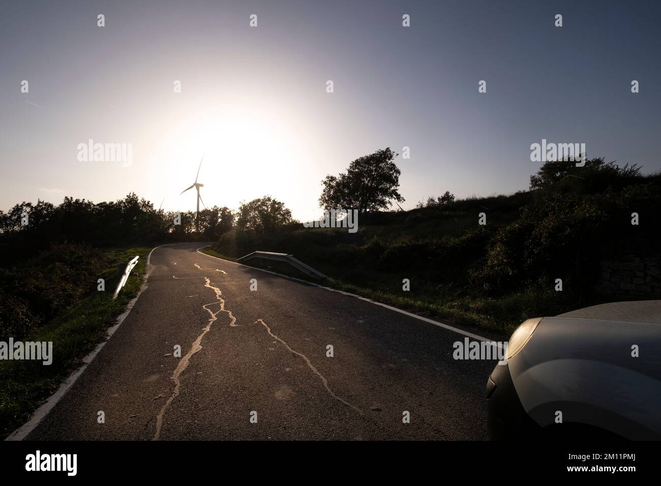 Straße auf landwirtschaftlichen Feldern mit Windkraftanlagen zur Erzeugung sauberer Elektrizität in Katalonien Spanien Stockfoto