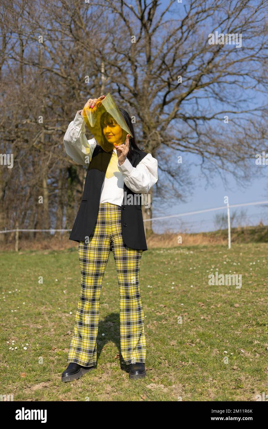 Modisch gekleidete Frau mit gelber Folie Stockfoto