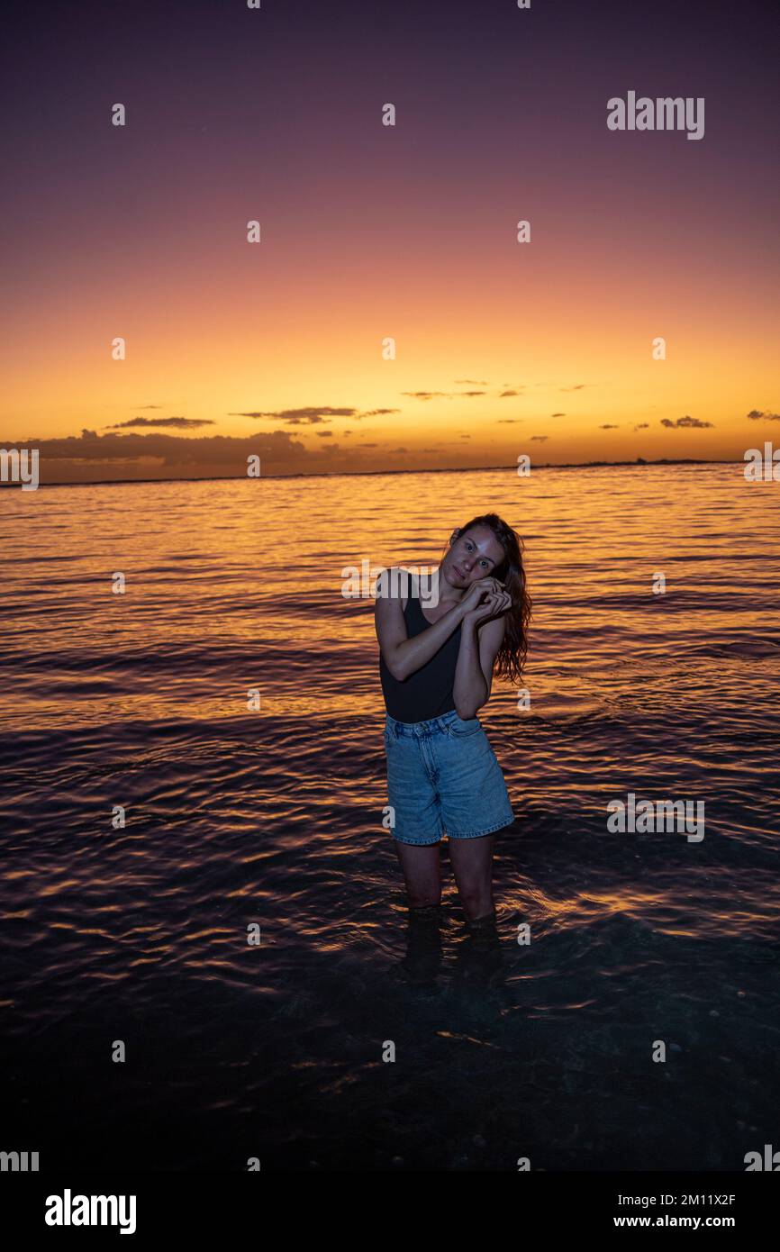 Eine junge Dame genießt die spektakulären Lichter bei Sonnenuntergang an einem der Strände auf mauritius Island, Afrika Stockfoto