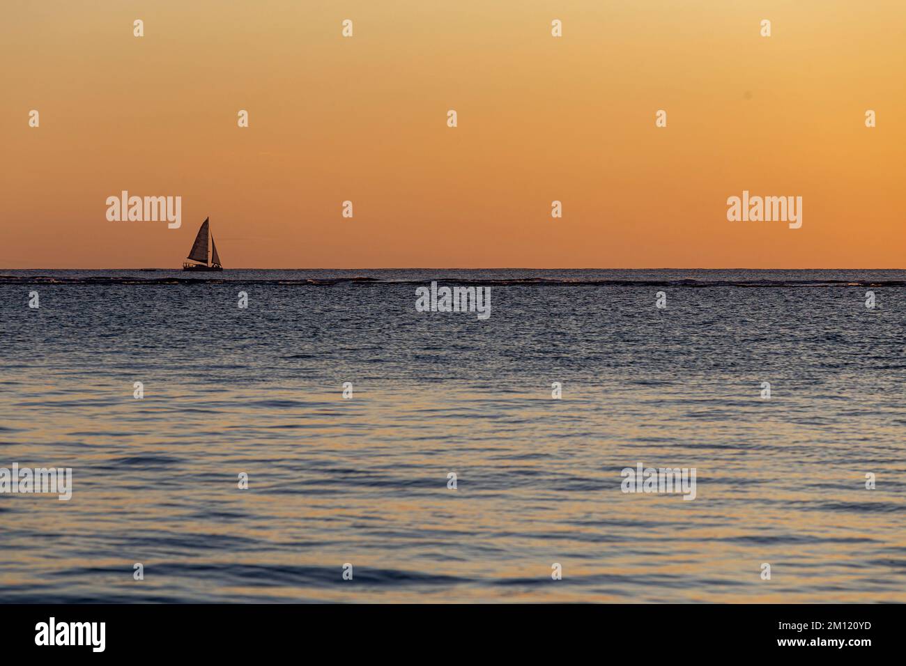 Ein einsames Salzwasser-Schiff am Horizont während des Sonnenuntergangs auf Mauritius Island, Afrika - Kopierraum Stockfoto