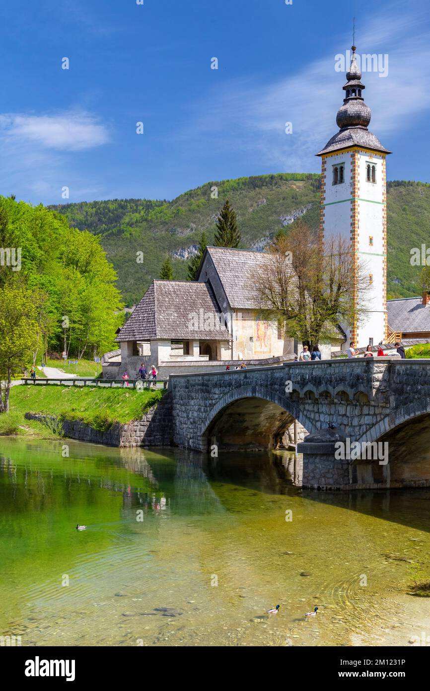 Kirche St. Johannes der Täufer und die Steinbrücke am Bohinj-See. Bohinj Lake, Slowenien, Europa. Stockfoto