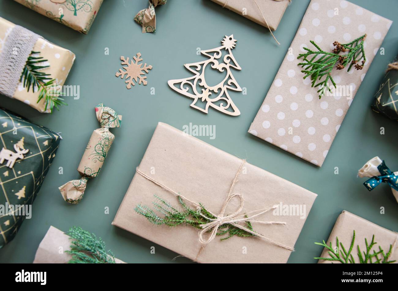 Umweltfreundliche Weihnachtsgestaltung mit Geschenkboxen aus wiederverwendbarem Papier und natürlicher Einrichtung auf blaugrünem Hintergrund, Draufsicht. Umgebung ohne Verschwendung Stockfoto