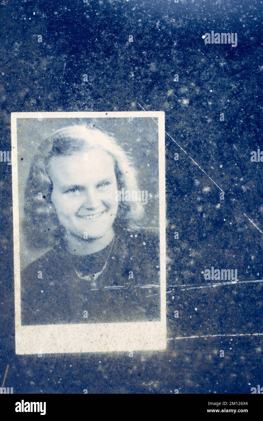 Altes Foto einer jungen Frau hinter einer schmutzigen Glasscheibe Stockfoto