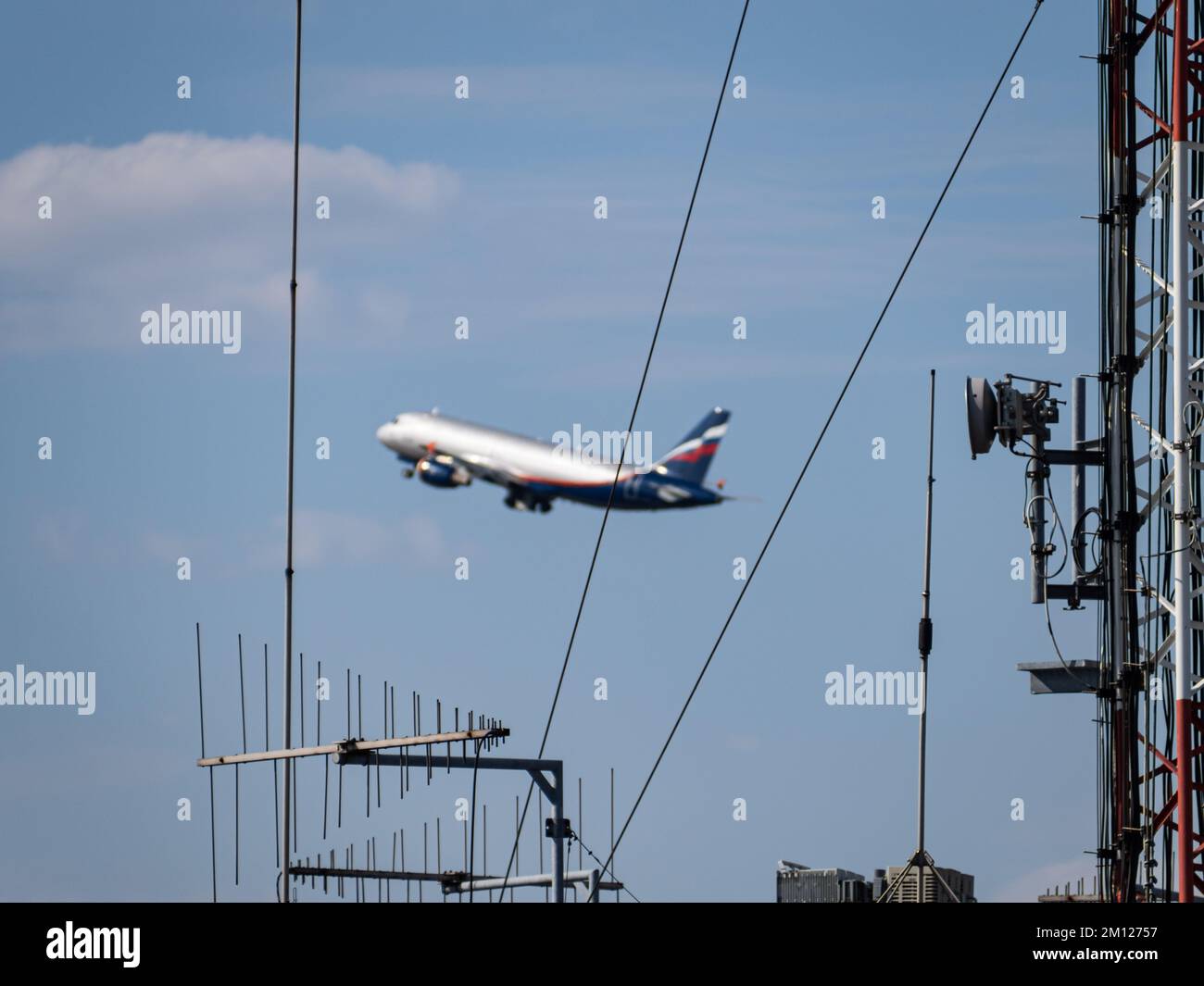 Verschwommene Silhouette eines russischen Passagierflugzeugs hinter dem Kontrollturm Stockfoto