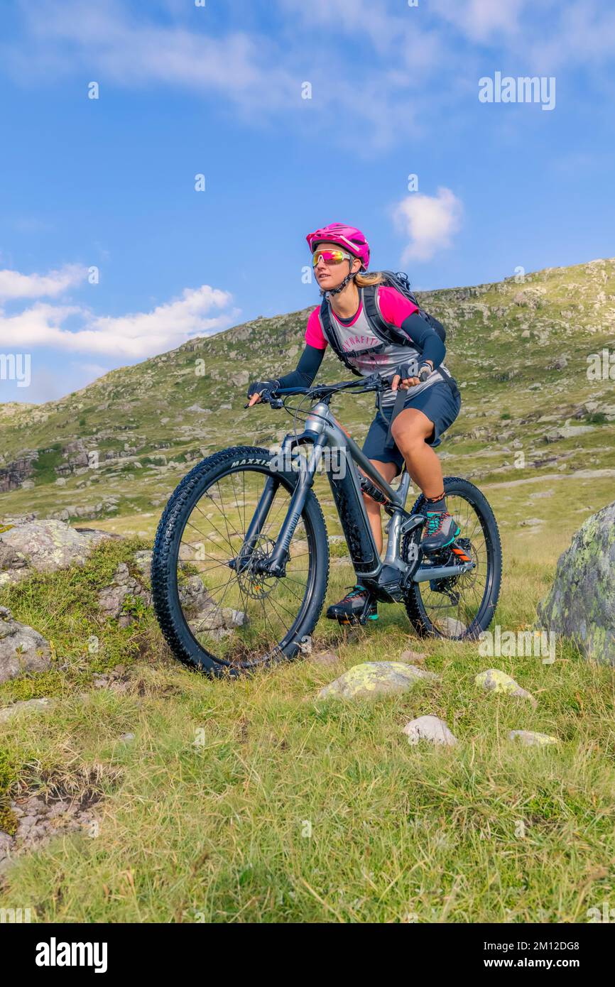 Italien, Venetien, Provinz Belluno, Falcade. Ein junges Mädchen, das ein E-Bike/e-mtb fährt, eine kostenlose Fahrt in den Dolomiten Stockfoto