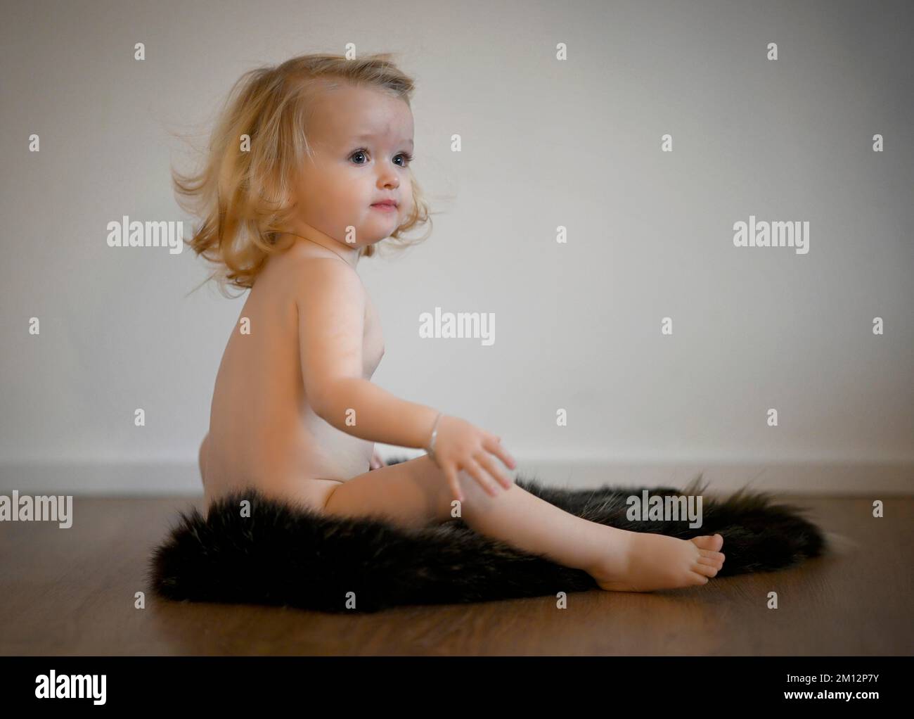 Mädchen, 14 Monate, auf Pelz sitzend, Stuttgart, Baden-Württemberg, Deutschland, Europa Stockfoto