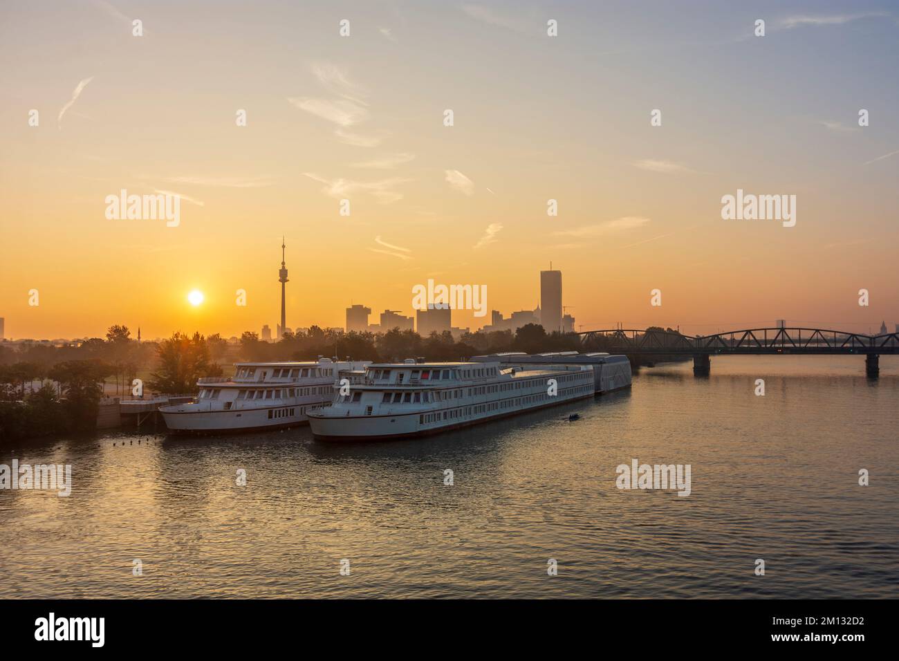 Wien, Sonnenaufgang an der Donau (Donau), Schulschiff Bertha-von-Suttner-Gymnasium, Blick auf Donauturm und Donaucity mit DC Tower 1, Nordbahnbrücke 22. Donaustadt, Österreich Stockfoto