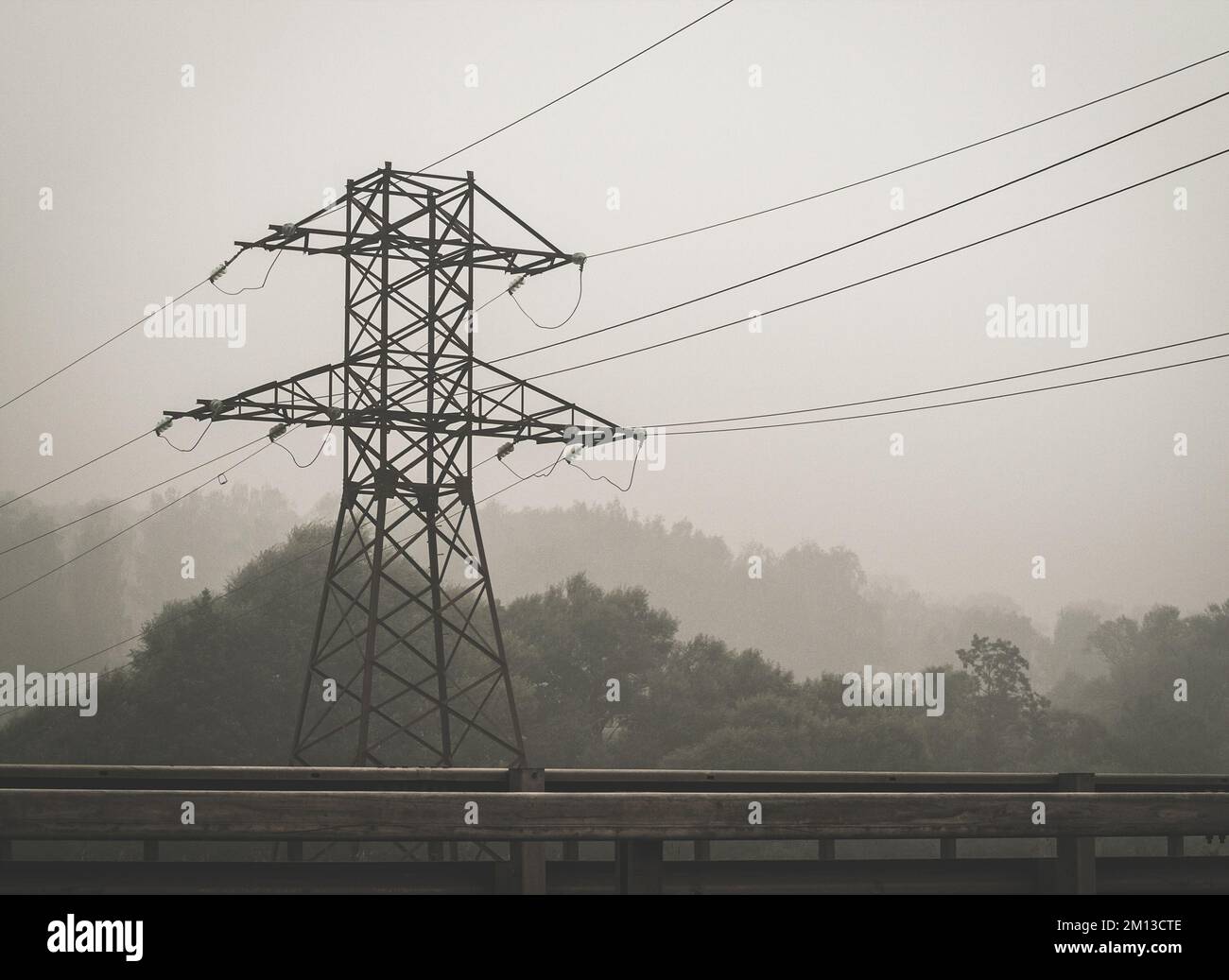 Hochspannungsmast am nebligen Morgen Stockfoto
