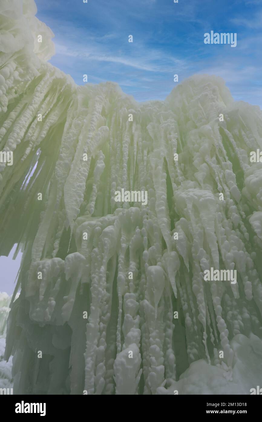 Eine majestätische Mauer aus Eis und Eiszapfen mit geschwollenem Schnee kontrastiert mit einem blauen Himmel mit Zirruswolken bei der Eisschlösser-Show am See Genev Stockfoto