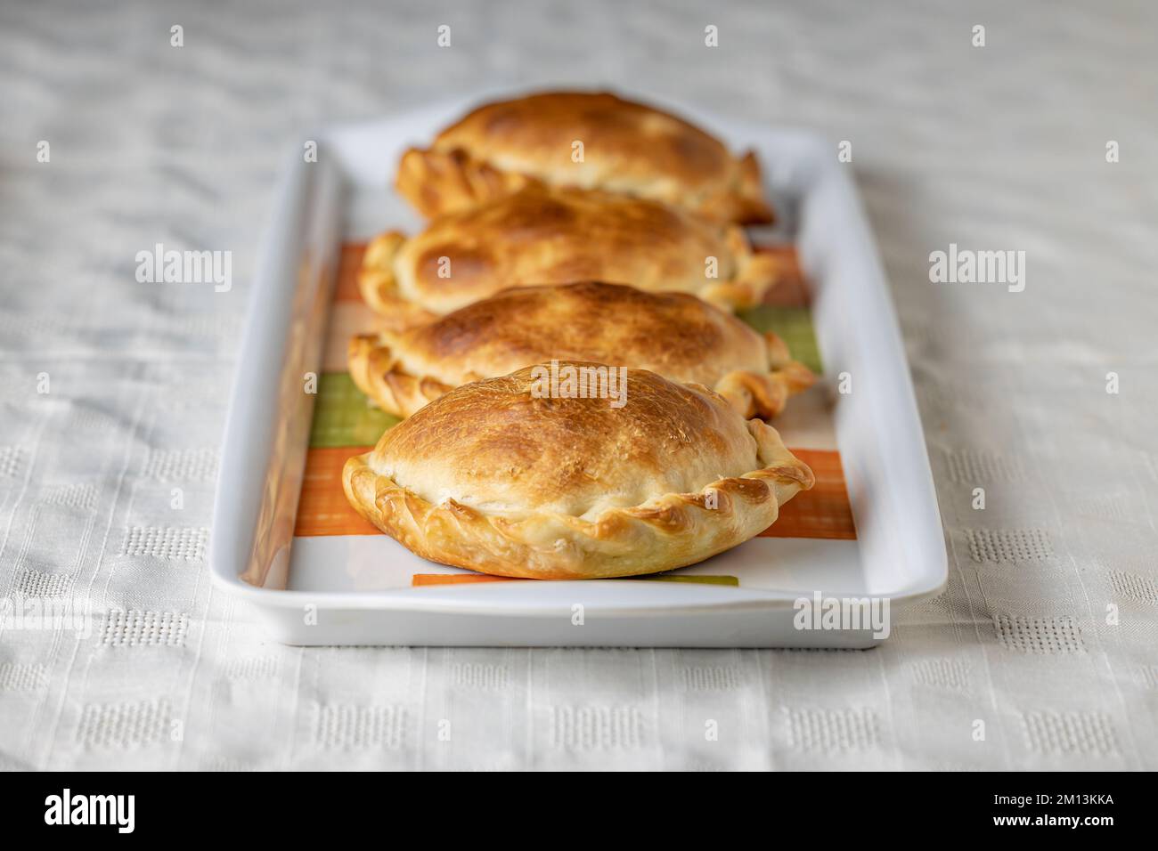 Argentinische Empanadas, gebacken auf einem Teller. Stockfoto