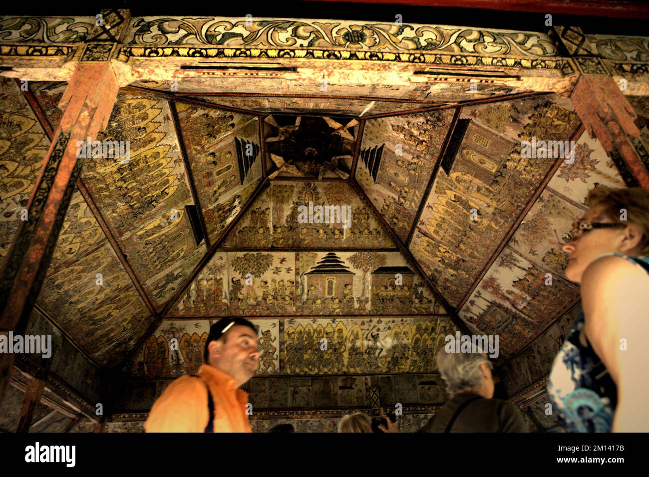 Touristen im Kertha Gosa, einem berühmten Pavillon, dessen Decke alte, traditionelle balinesische Kamasan-Malerei zeigt, in Klungkung, Bali. Stockfoto