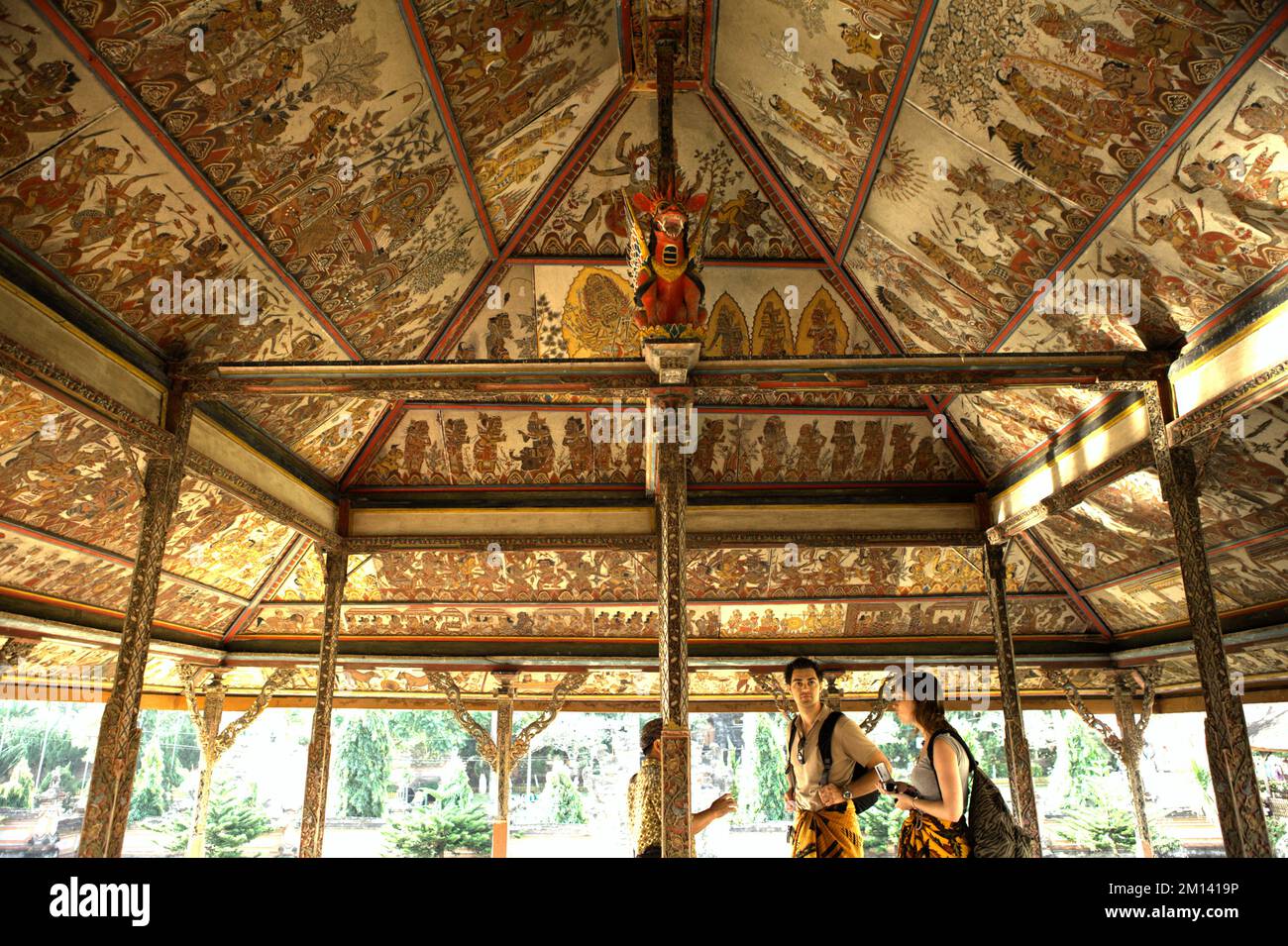Besucher besuchen Kertha Gosa, einen berühmten Pavillon, dessen Decke alte, traditionelle balinesische Kamasan-Malereien zeigt, der sich in Klungkung, Bali, befindet. Stockfoto