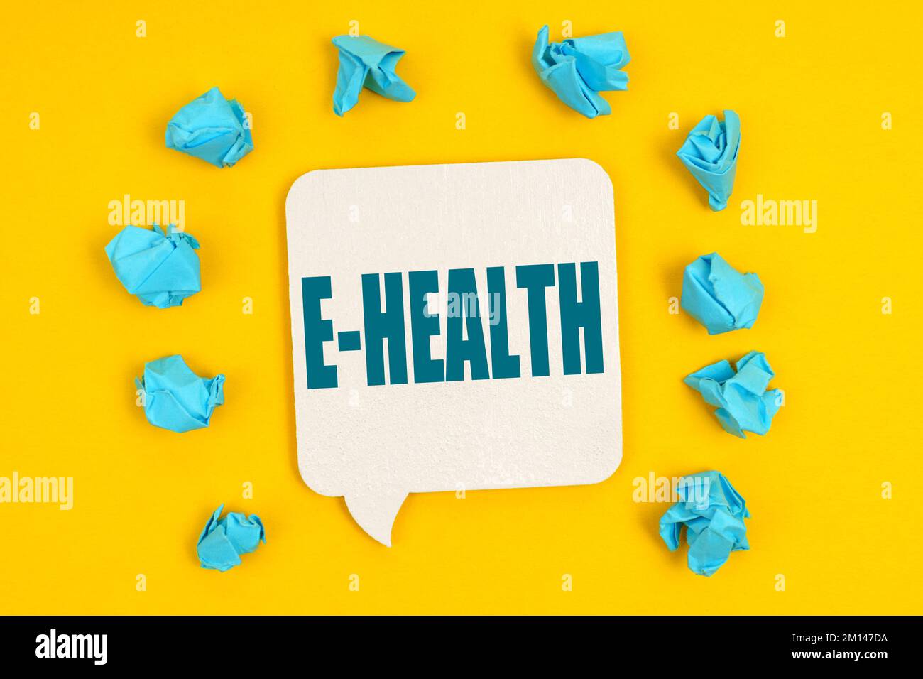 Medizinisches Konzept. Auf gelbem Hintergrund, blaue Papierstücke und ein Schild mit der Inschrift - E-HEALTH Stockfoto