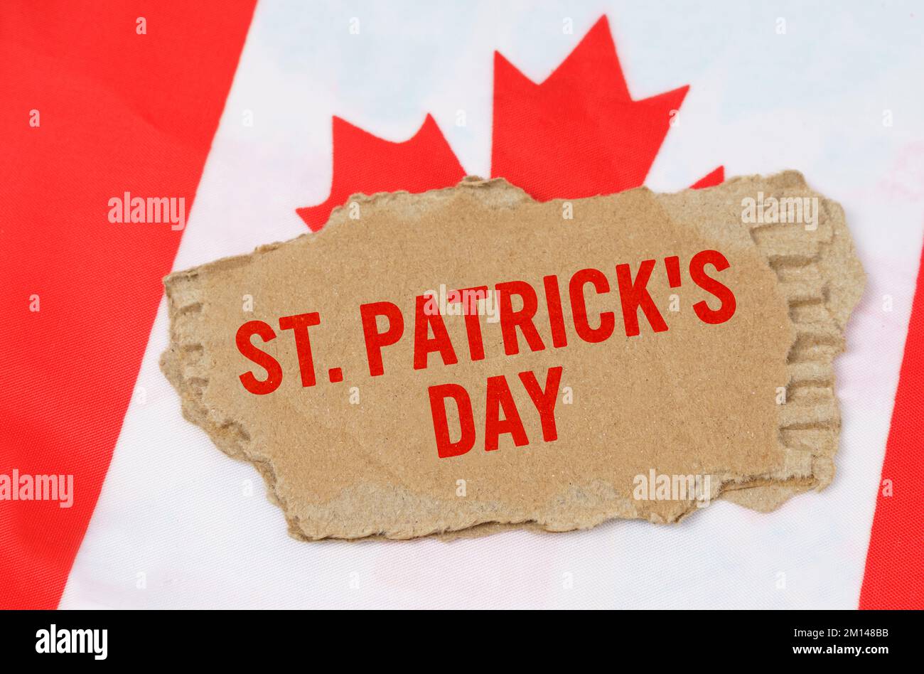 Urlaub in Kanada. Vor dem Hintergrund der kanadischen Flagge liegt Pappe mit der Inschrift St. Tag Der Patricks Stockfoto