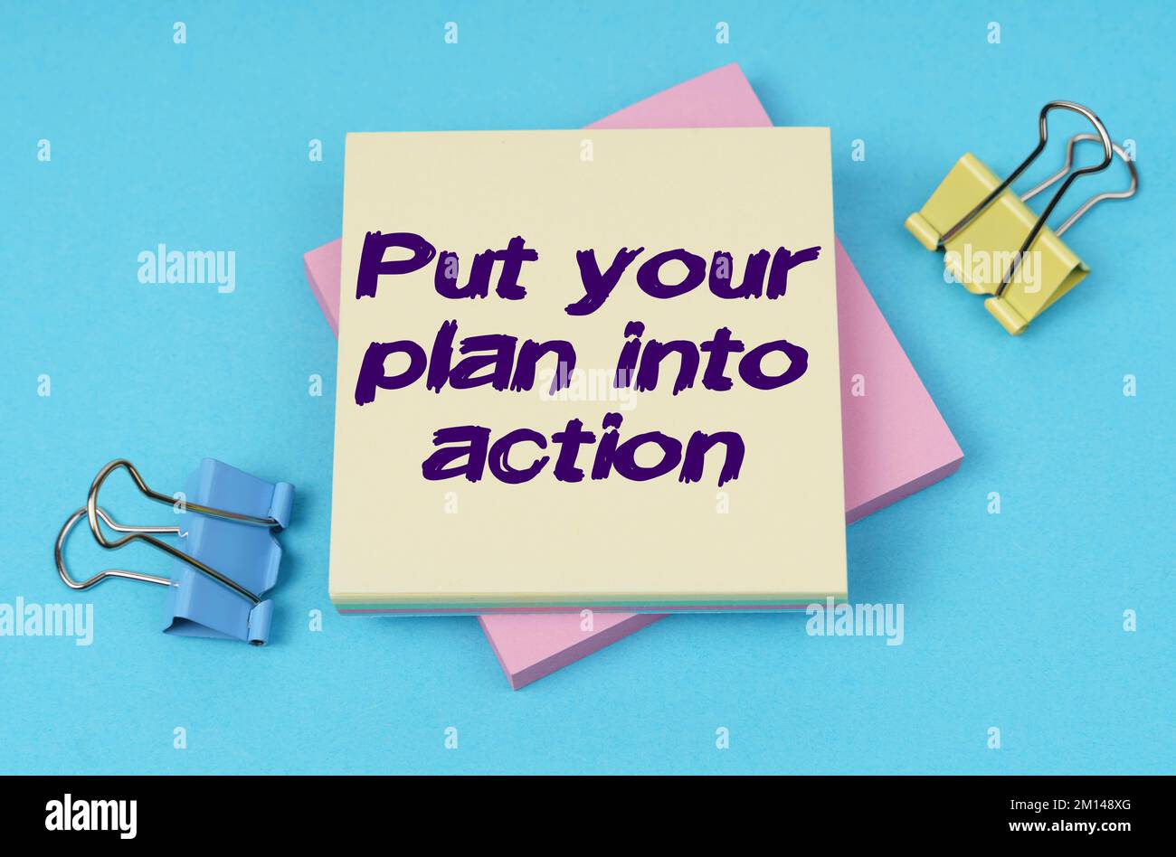 Geschäfts- und Finanzkonzept. Auf dem Tisch befinden sich Büroklammern, Notizpapier mit Text – setzen Sie Ihren Plan in die Tat um Stockfoto