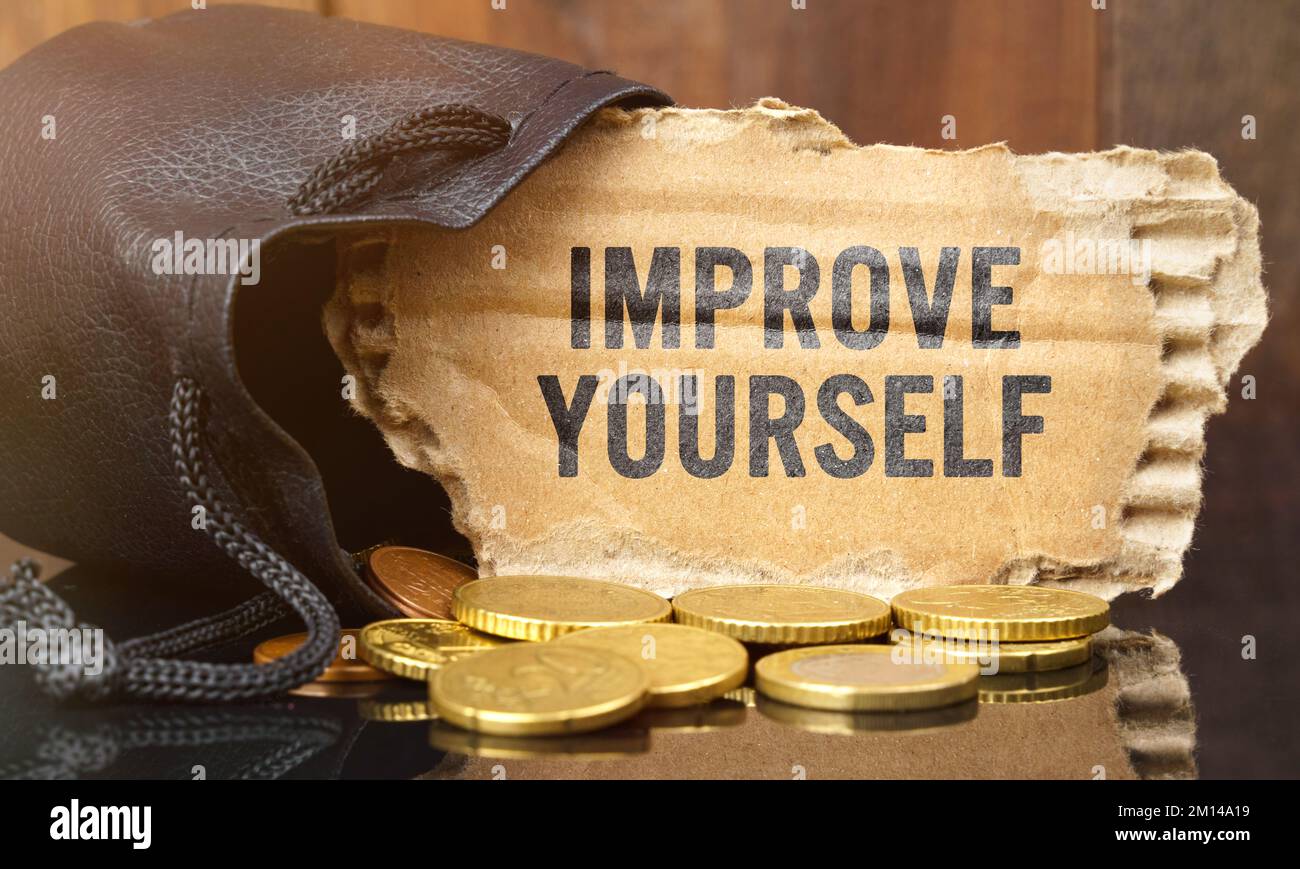 Geschäfts- und Finanzkonzept. Auf dem Tisch liegt eine Tasche voller Geld, aus der Pappe mit der Inschrift hervorsteht - VERBESSERN SIE SICH Stockfoto