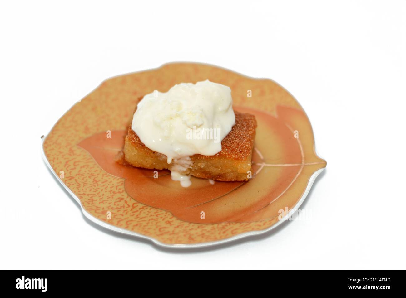 Basbusa ist ein Stück Basbosa mit cremigem Qeshta und gesättigt mit Honigzuckersirup. Basbusa ist ein Dessert aus dem Nahen Osten, das normalerweise in Ramad gebacken wird Stockfoto