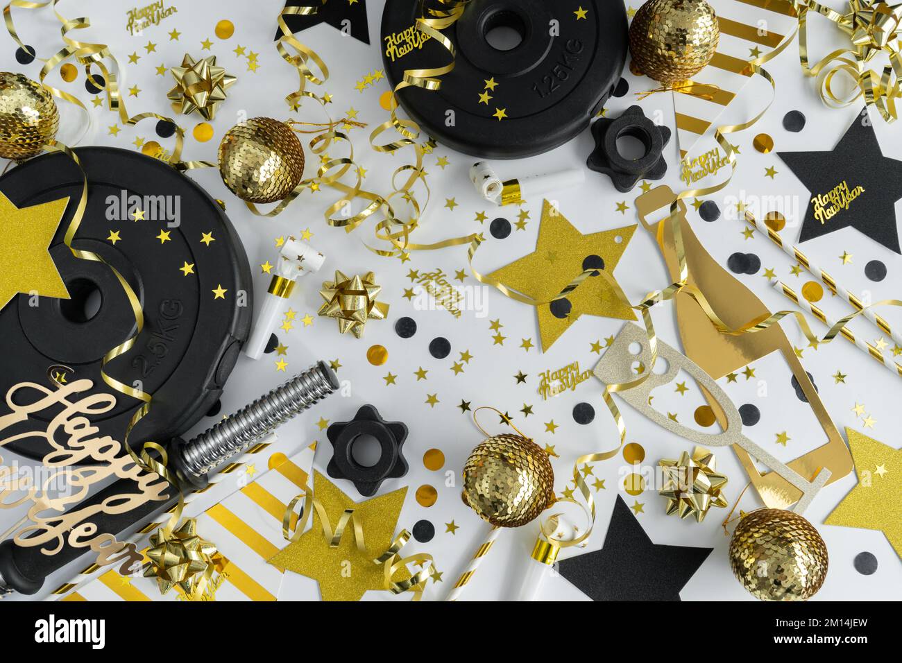 Gym-Kurzhanteln-Gewichtsteller, goldene Dekorationen, Konfetti, Partystreuer für Silvesterfeier. Workout-Vorsatz, frohes neues Jahr, flaches Lay. Stockfoto
