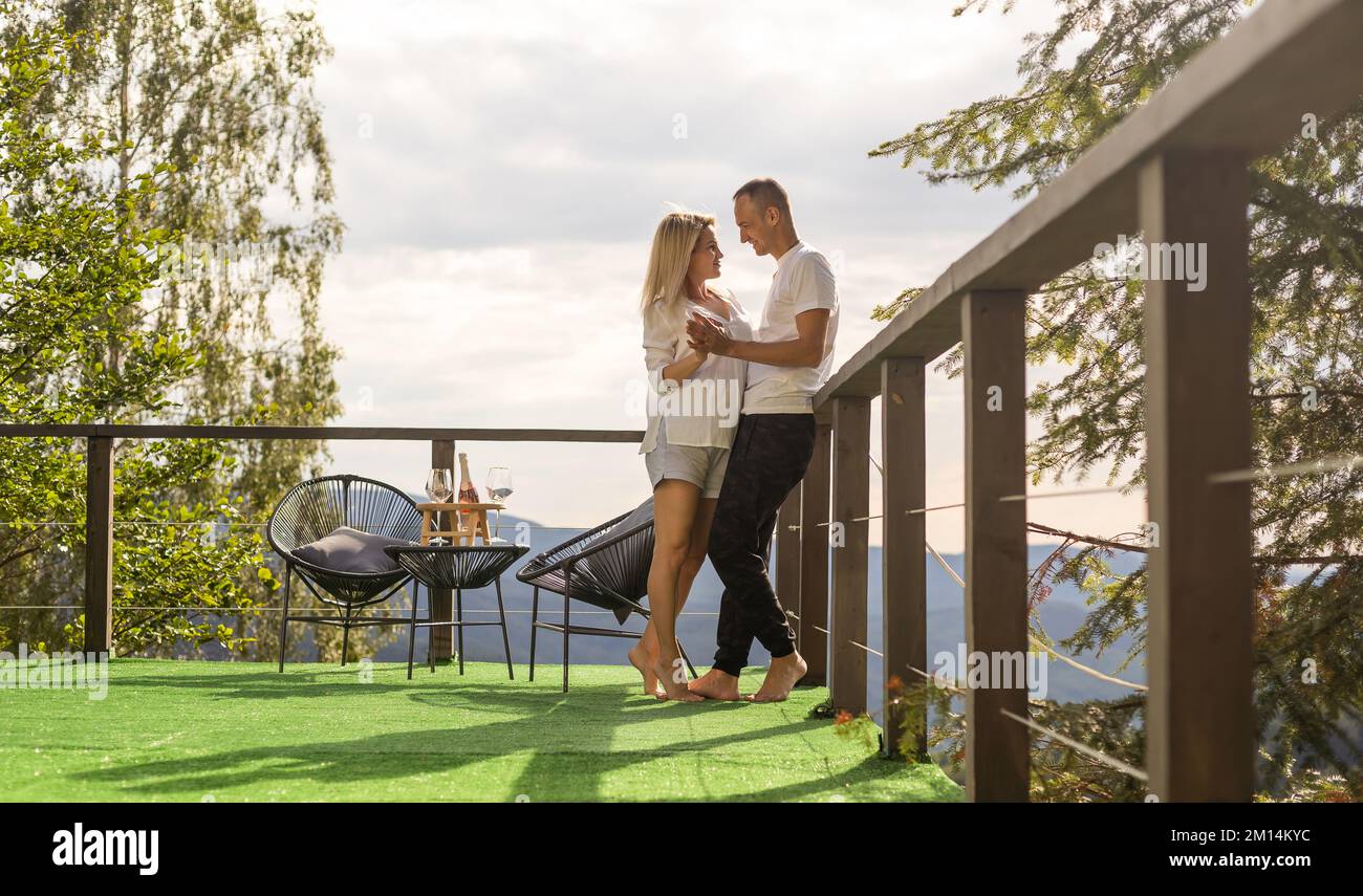 Paar auf dem Balkon vor dem Hintergrund der Berge. Life Terrasse ziemlich Glück Sommerhaus. Stockfoto