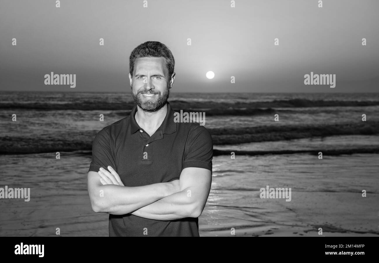 Fröhlicher Mann über dem Meer am Sonnenuntergang Sommerstrand, Platz kopieren, Urlaub Stockfoto