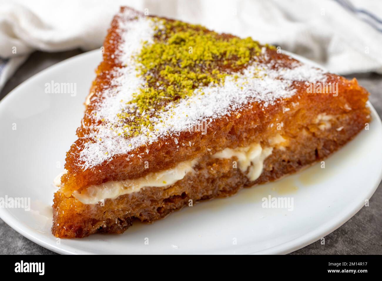 Brot-Kadayif-Dessert mit Sahne auf dunklem Hintergrund. Türkische Küche Desserts. Schließen Stockfoto