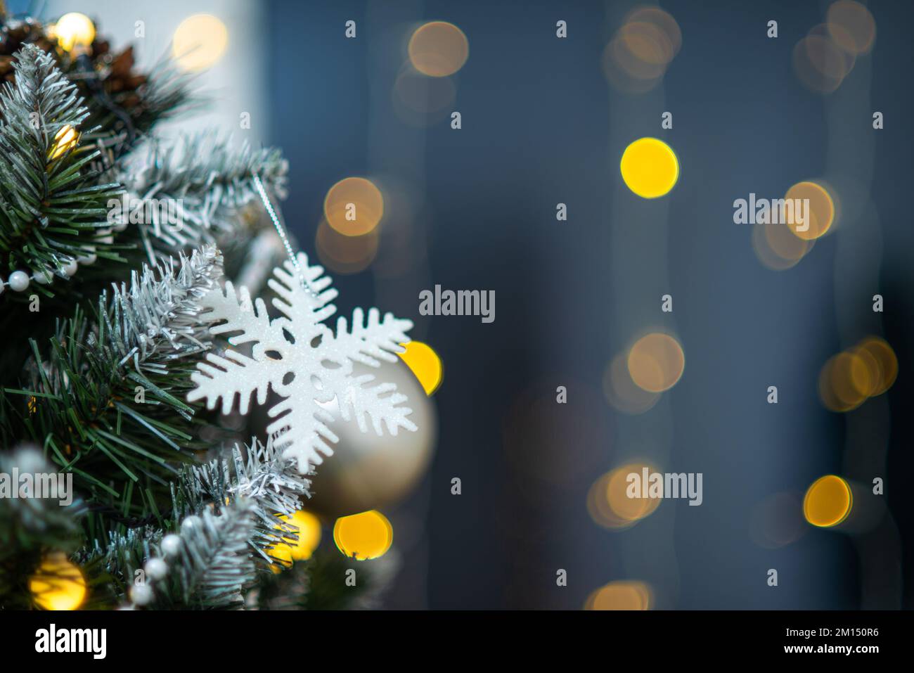 Nahaufnahme eines dekorierten Weihnachtsbaums. Schneeflocke. Bokeh-Lichter. Stockfoto