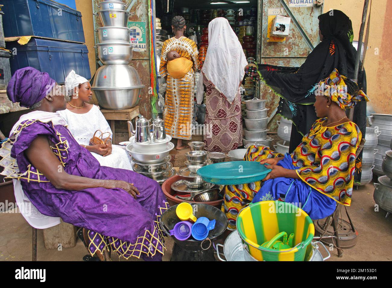 Frauen, die Blecheimer und -Töpfe auf dem lokalen Markt in Bamako, Mali, Westafrika kaufen. Stockfoto
