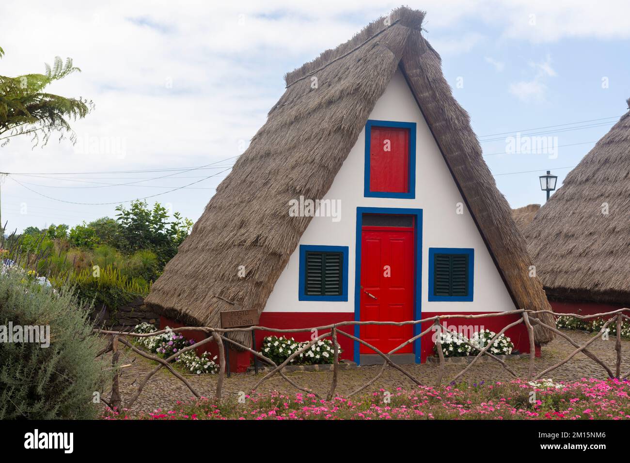 Eine wunderschöne Hütte mit leuchtenden roten und blauen Details auf der Fassade in Madeira, Portugal Stockfoto
