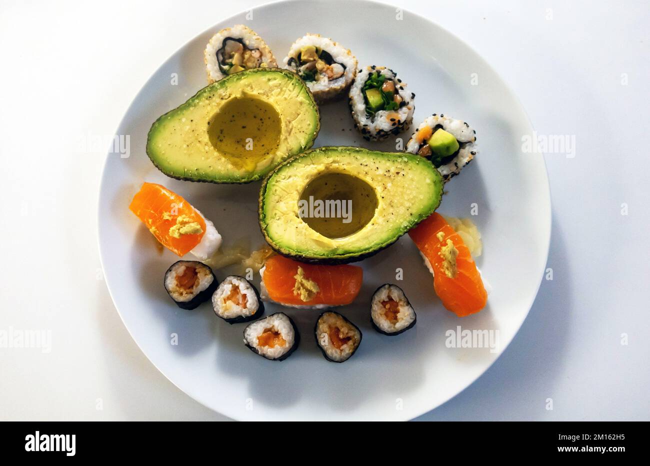 Avocado mit Olivenöl und Lachs-Sushi Stockfoto