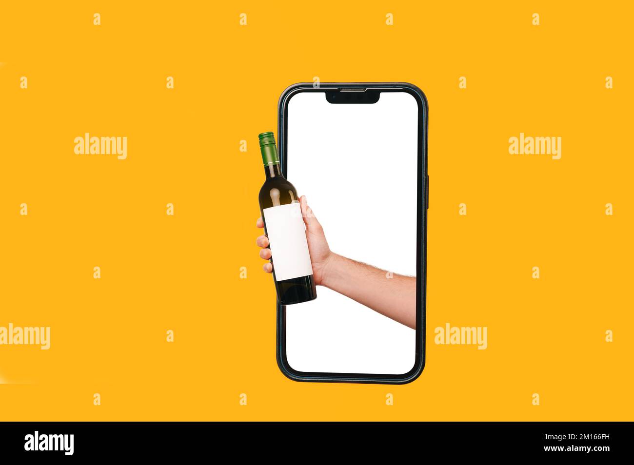 Ein Mann mit einer Flasche Wein kommt aus einem großen Telefon. Studio-Vorlage mit gelbem Hintergrund. Stockfoto