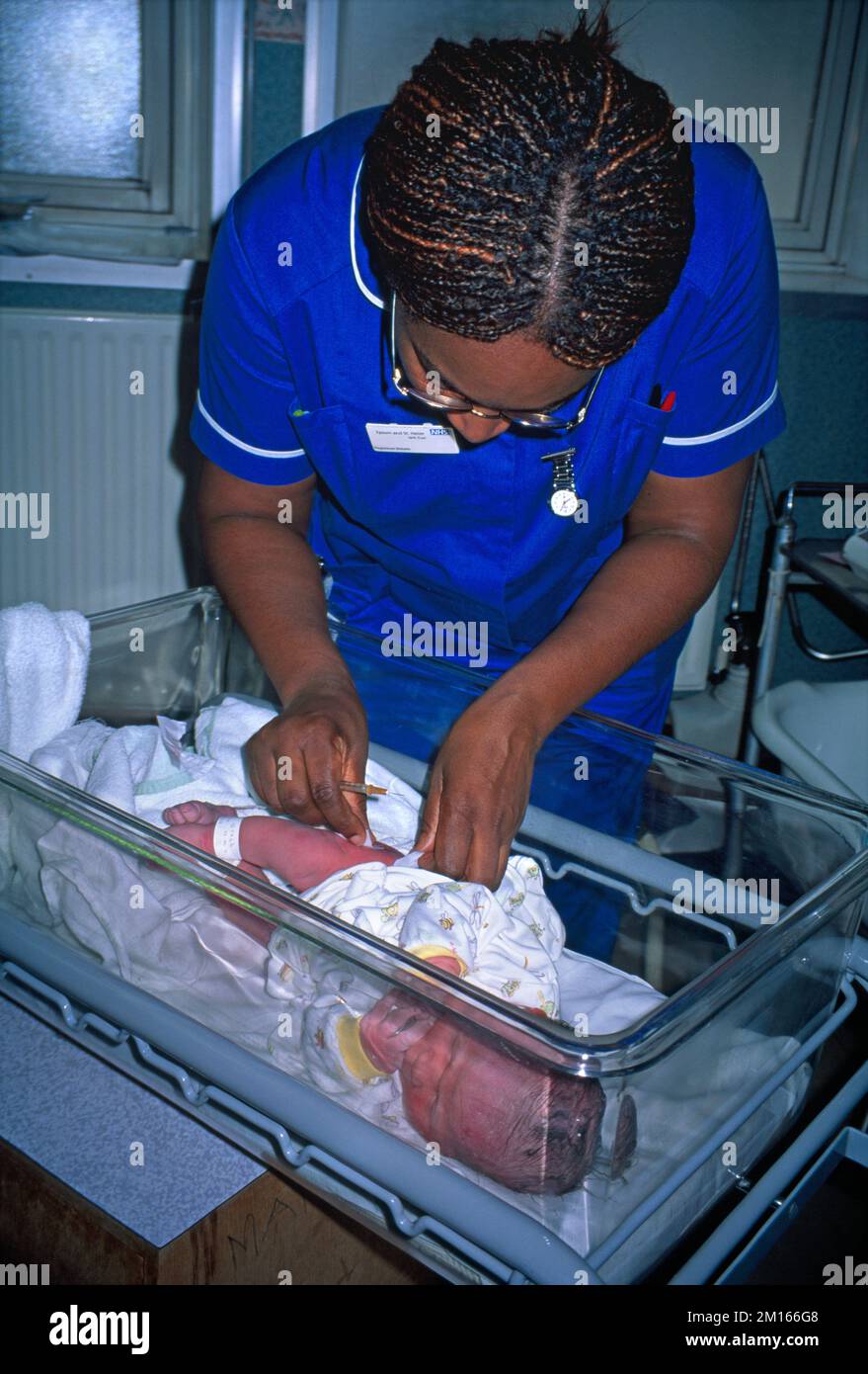 Kreißsaal im Krankenhaus Hebamme gibt Neugeborenen-Vitamin-K-Injektion Stockfoto