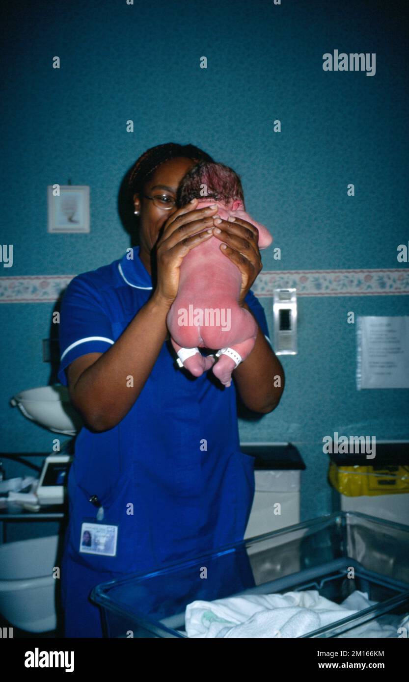 Kreißsaal im Krankenhaus mit Hebamme in der Hand von New Born Baby England Stockfoto
