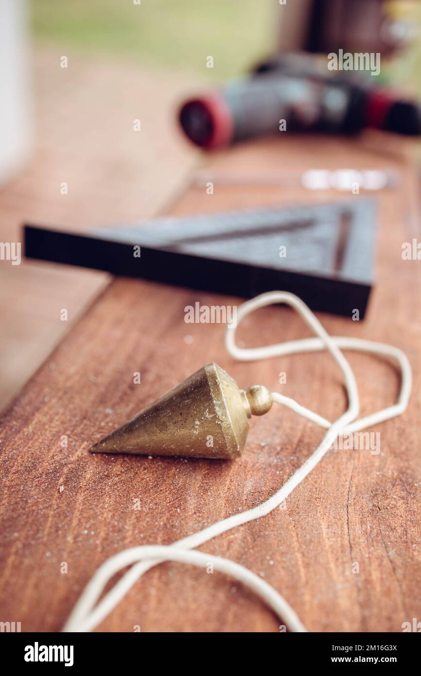 Nahaufnahme eines Pendels, Bauwerkzeug auf dem Tisch Stockfoto