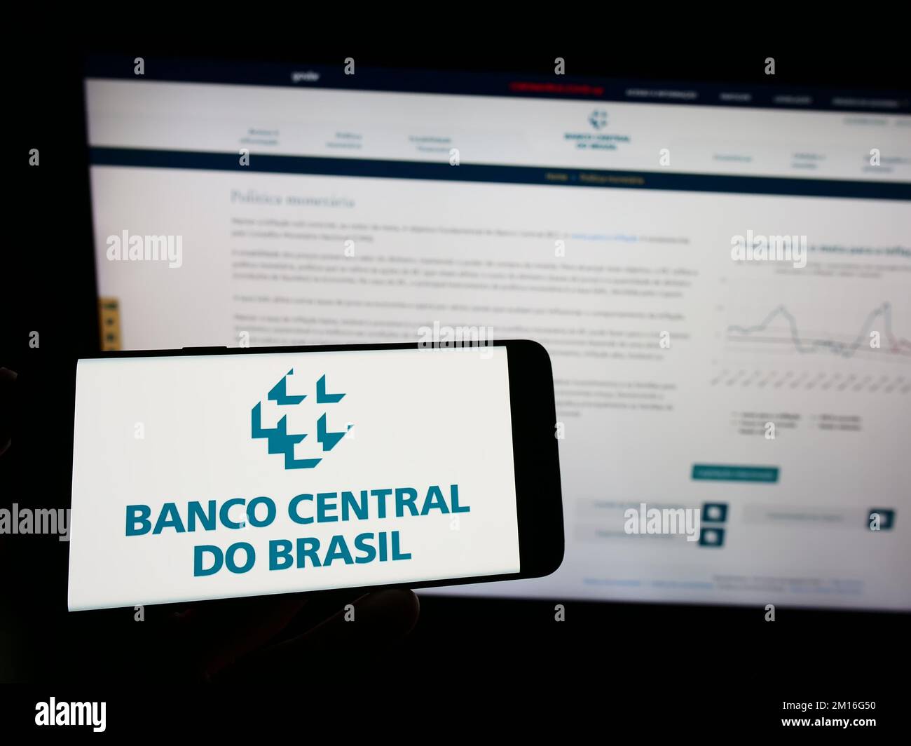 Person, die ein Mobiltelefon mit dem Logo der Zentralbank Banco Central do Brasil (BCB) auf dem Bildschirm vor der Webseite hält. Konzentrieren Sie sich auf das Display des Telefons. Stockfoto