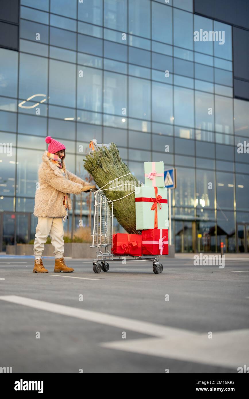 Frau kauft Weihnachtsbaum und Geschenke im Einkaufszentrum Stockfoto