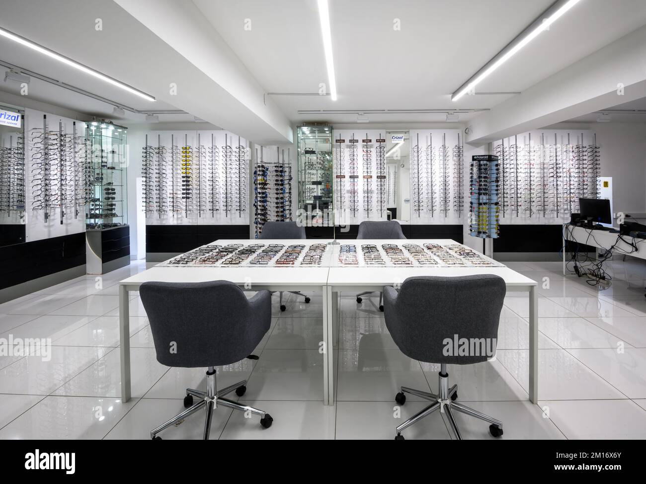 Innenraum des Optikgeschäfts, verschiedene Gläser befinden sich im Optikergeschäft. Panorama von Ausstellungsräumen und Tisch im weißen Designgeschäft. Thema o Stockfoto