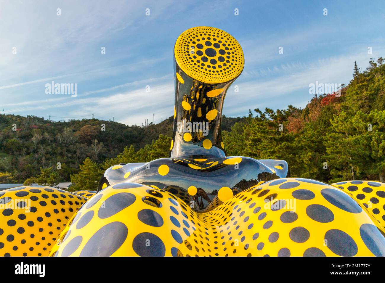 Der gebogene, spiegelnde Stiel ist ein Detail der Skulptur "Gelber Kürbis" von Yayoi Kusama auf der Kunstinsel Naoshima, Japan. Ein Taifun fegte die ursprüngliche Skulptur, die seit 1994 dort stand, im August 2021 ins Meer. Im Oktober 2022 ersetzte Kusama persönlich die Arbeit durch einen neuen Kürbis mit verstärkten Außenwänden rechtzeitig zur Setouchi-Triennale. Stockfoto