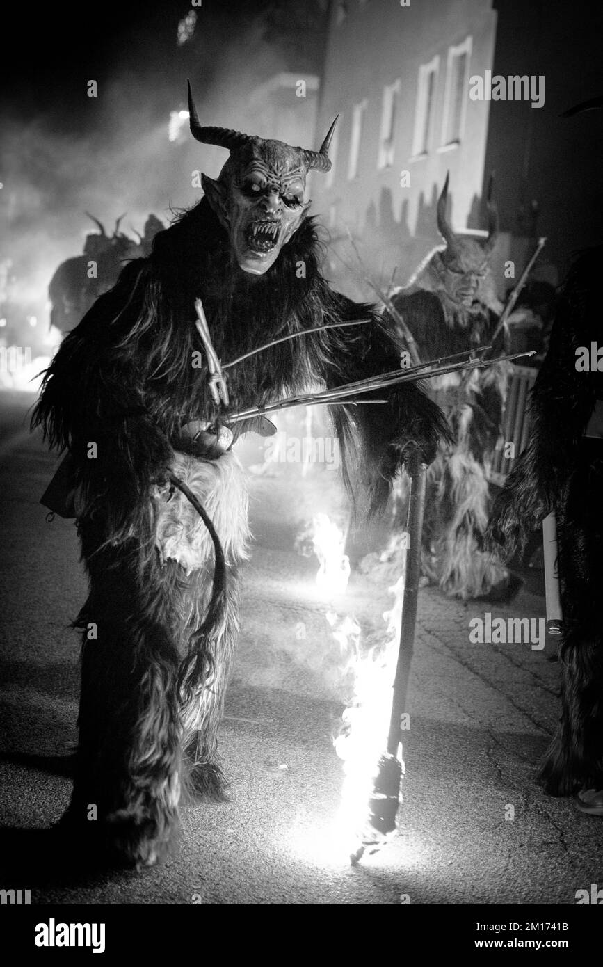 Maskierte Teufelsbiester paradieren durch das Dorf und erschrecken die Menge, während diese folklorische alpine Tradition am Leben erhalten bleibt Stockfoto