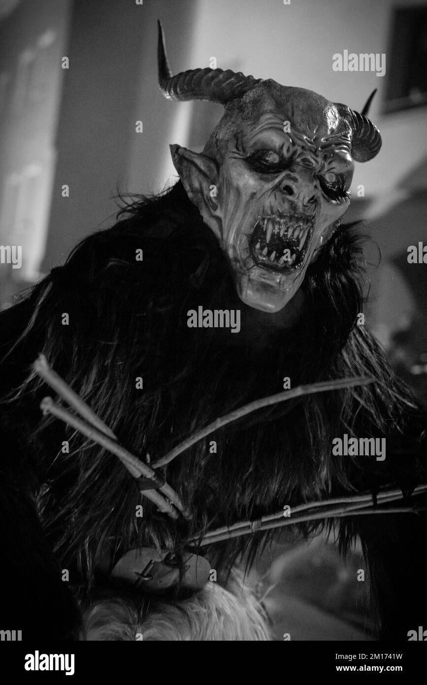 Maskierte Teufelsbiester paradieren durch das Dorf und erschrecken die Menge, während diese folklorische alpine Tradition am Leben erhalten bleibt Stockfoto