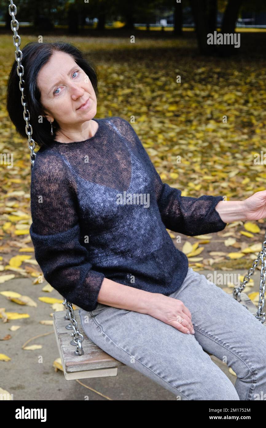 Porträt einer glücklichen lächelnden erwachsenen Seniorin vor dem Hintergrund des Herbstparks Stockfoto