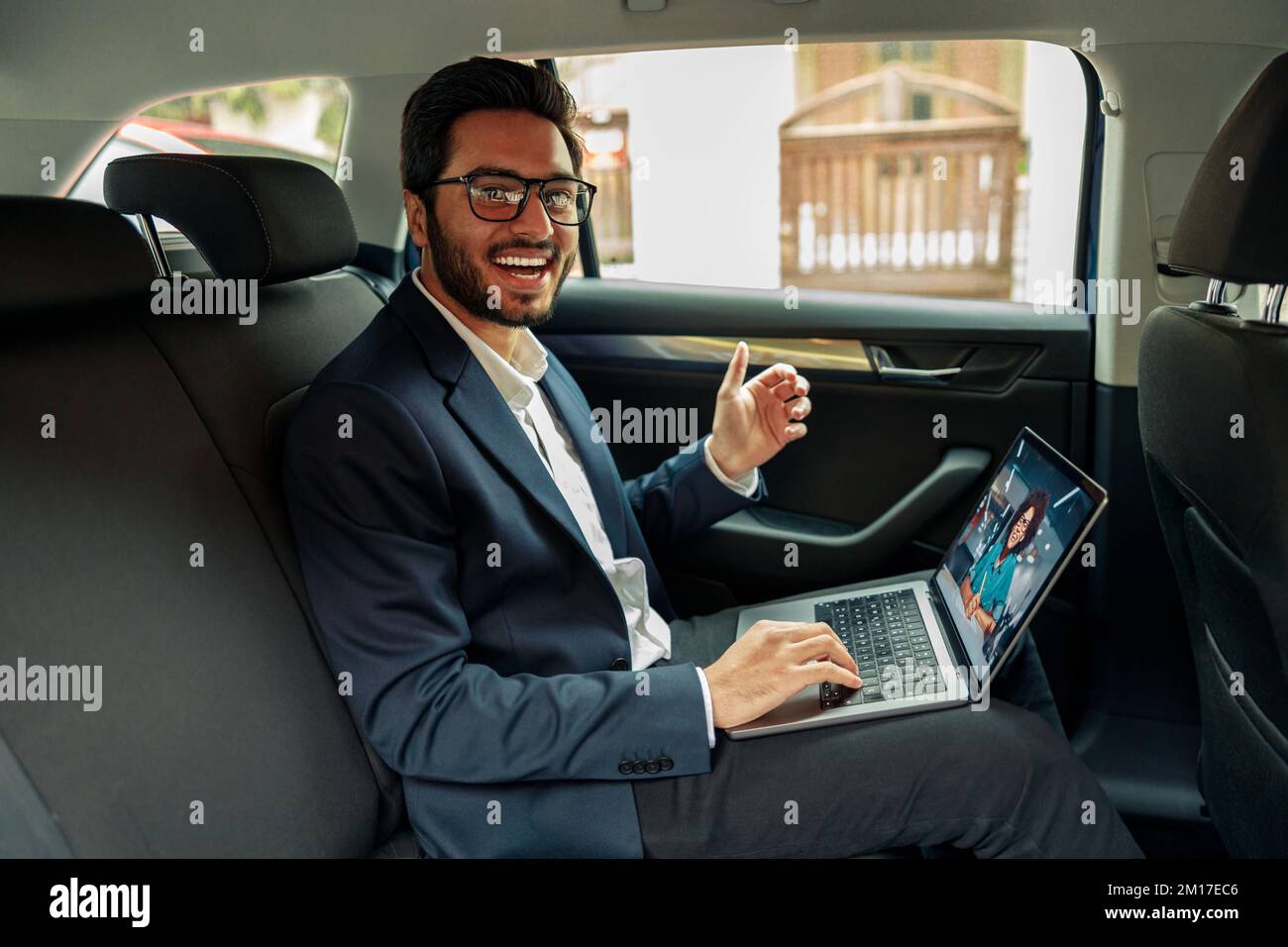 Ein Geschäftsmann hält per Videoanruf ein Geschäftstreffen ab, während er mit dem Auto zum Büro fährt Stockfoto