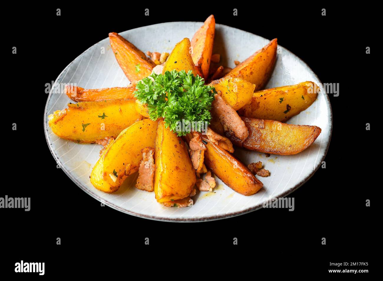 Rustikale Kartoffelkeile mit Speck auf schwarzem Hintergrund, Draufsicht Stockfoto