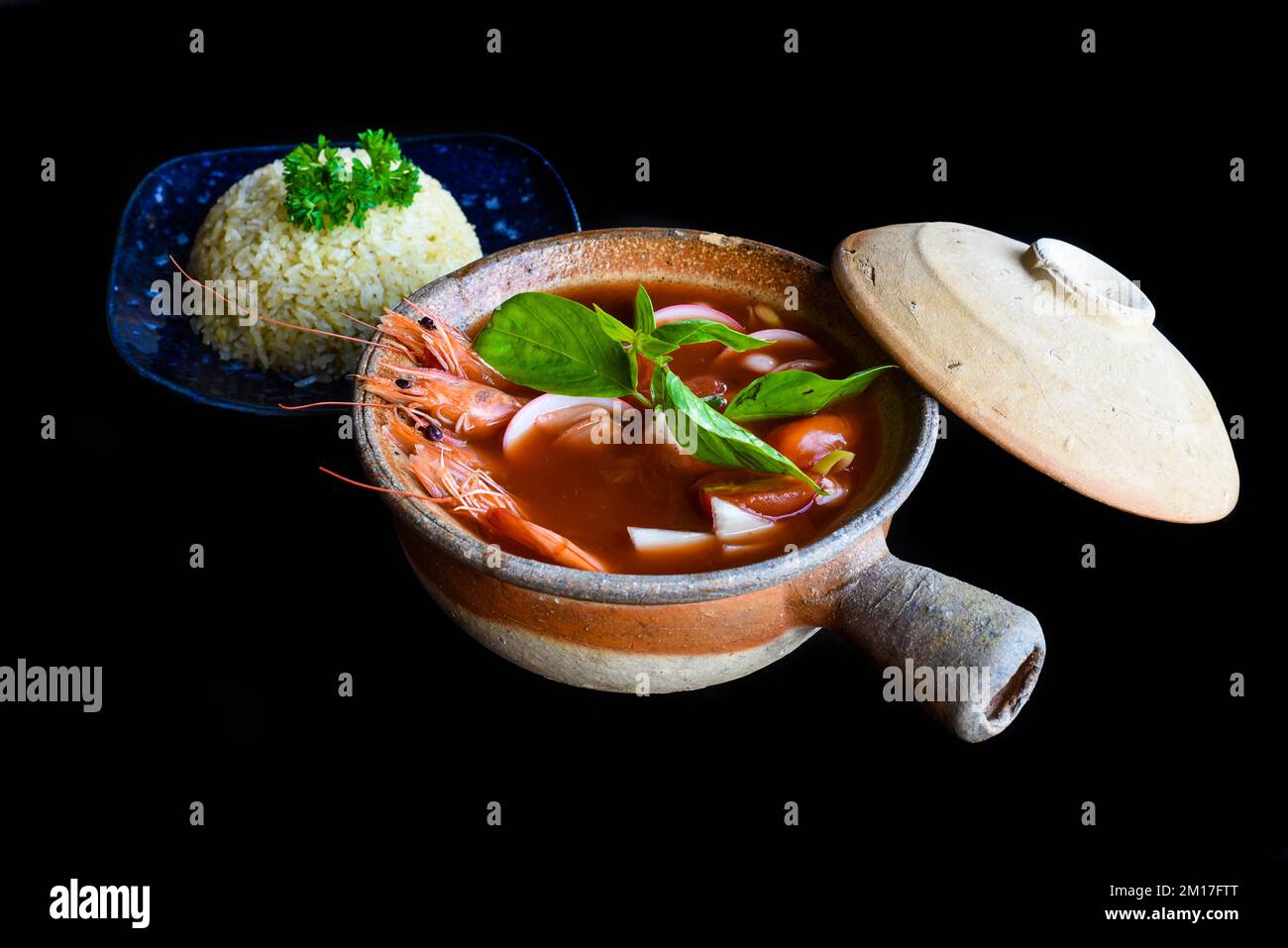 Suppe tom Yum mit isoliertem Reis auf schwarzem Hintergrund, Seitenansicht Stockfoto