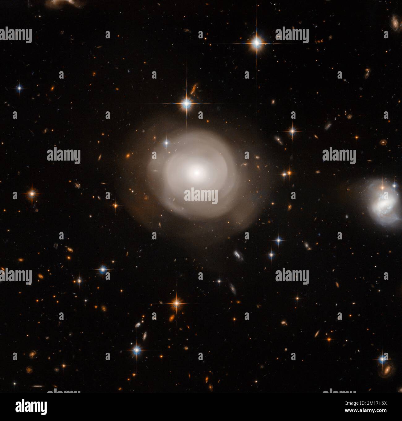 Kollision eines Sternenhams, der einen großen, leuchtenden Stern und ferne Galaxien im Hintergrund erzeugt. Digital optimiert. Bildelemente von der NASA Stockfoto