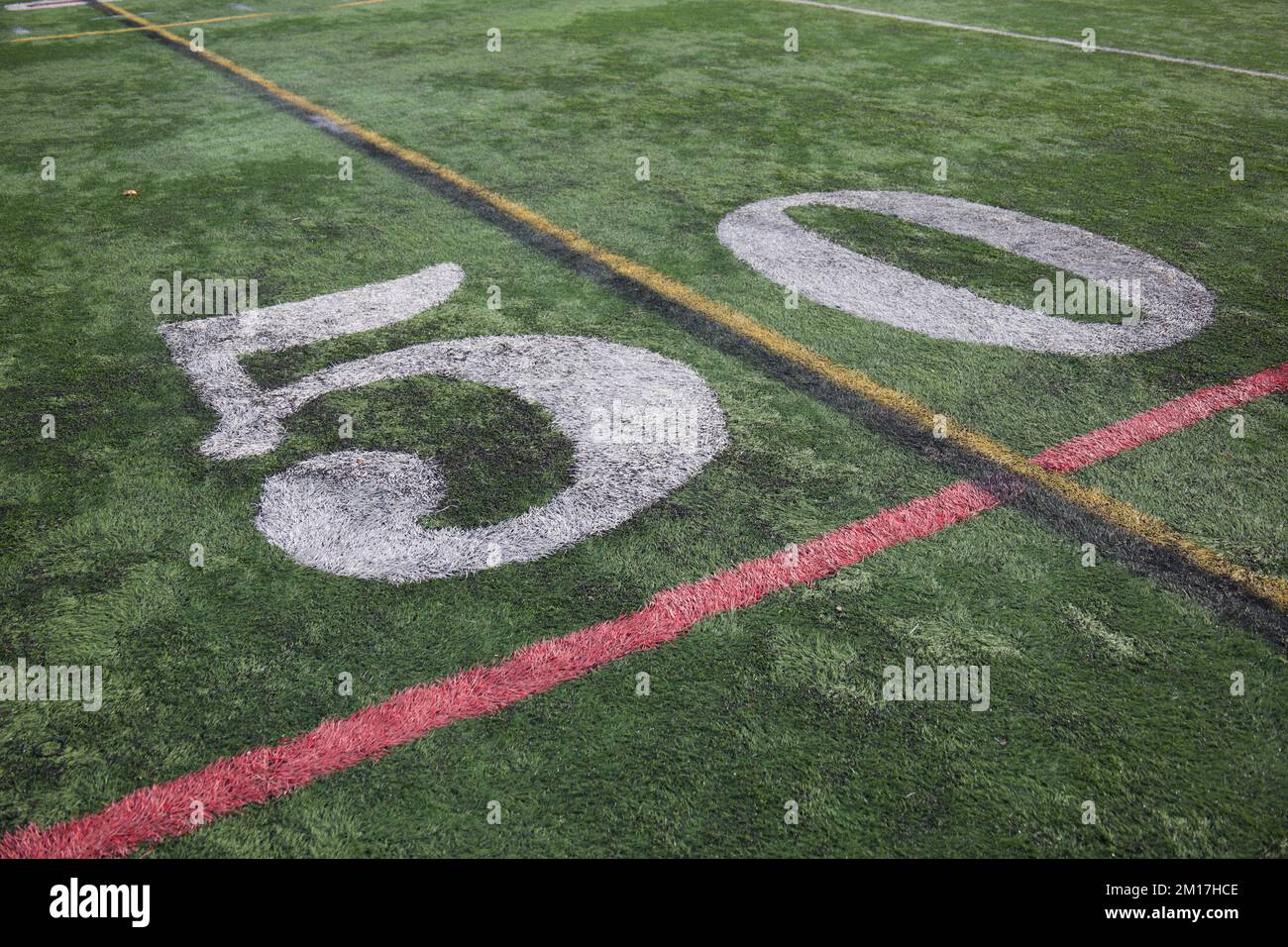 50 Yard Linie auf einem amerikanischen High School Fußballfeld mit weißen Ziffern und grünem Rasen, zusammen mit zusätzlichen Linien. Stockfoto