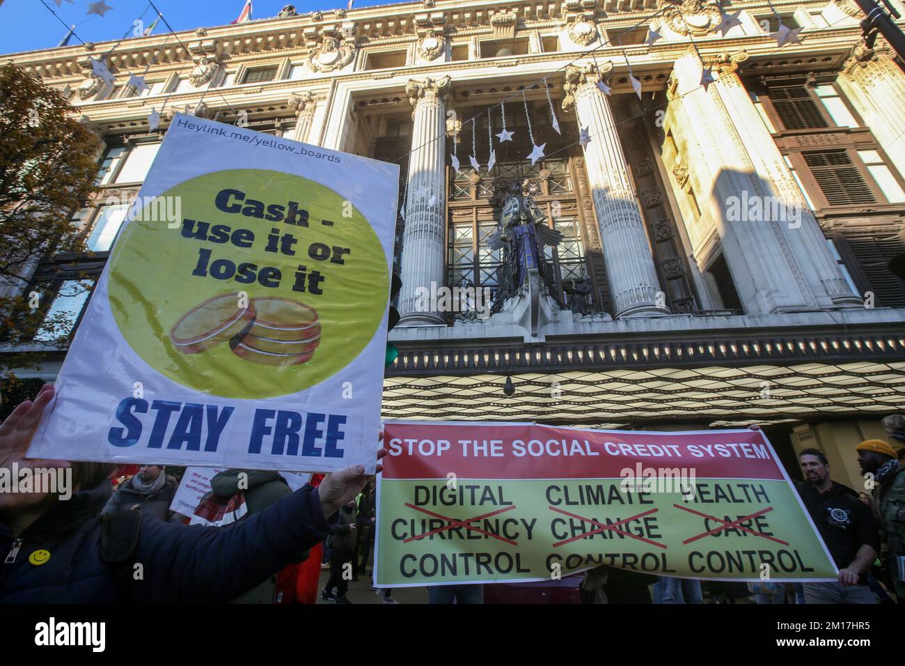 London, Großbritannien. 01.. Januar 2000. Ein Protestteilnehmer hält während der Demonstration ein Plakat mit der Aufschrift „Cash - use it or lose it“ vor dem Kaufhaus Selfridges. Demonstranten kamen zusammen und marschierten im Zentrum Londons mit Brettern und Schildern gegen die Regierung und andere „Eliten“, von denen sie glauben, dass sie sie versklavt werden. Sie protestieren gegen die digitale ID, eine digitale Währung, 15-Minuten-Städte, Net Zero und die Bedrohung durch Klimasperren. (Foto: Martin Pope/SOPA Images/Sipa USA) Guthaben: SIPA USA/Alamy Live News Stockfoto