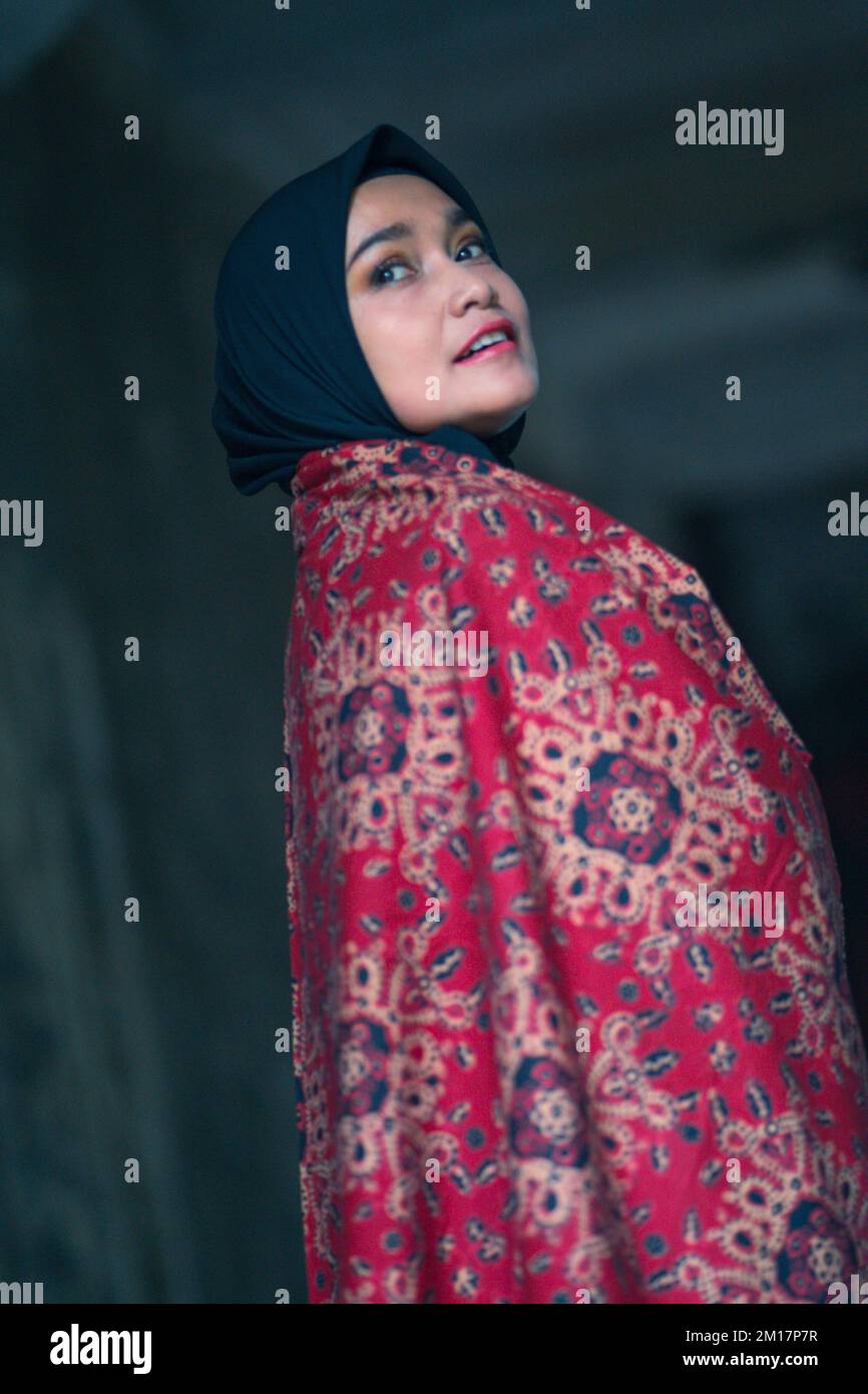 Schöne Frau in schwarzem Hijab in Batik aus Jambi, Indonesien. Stockfoto