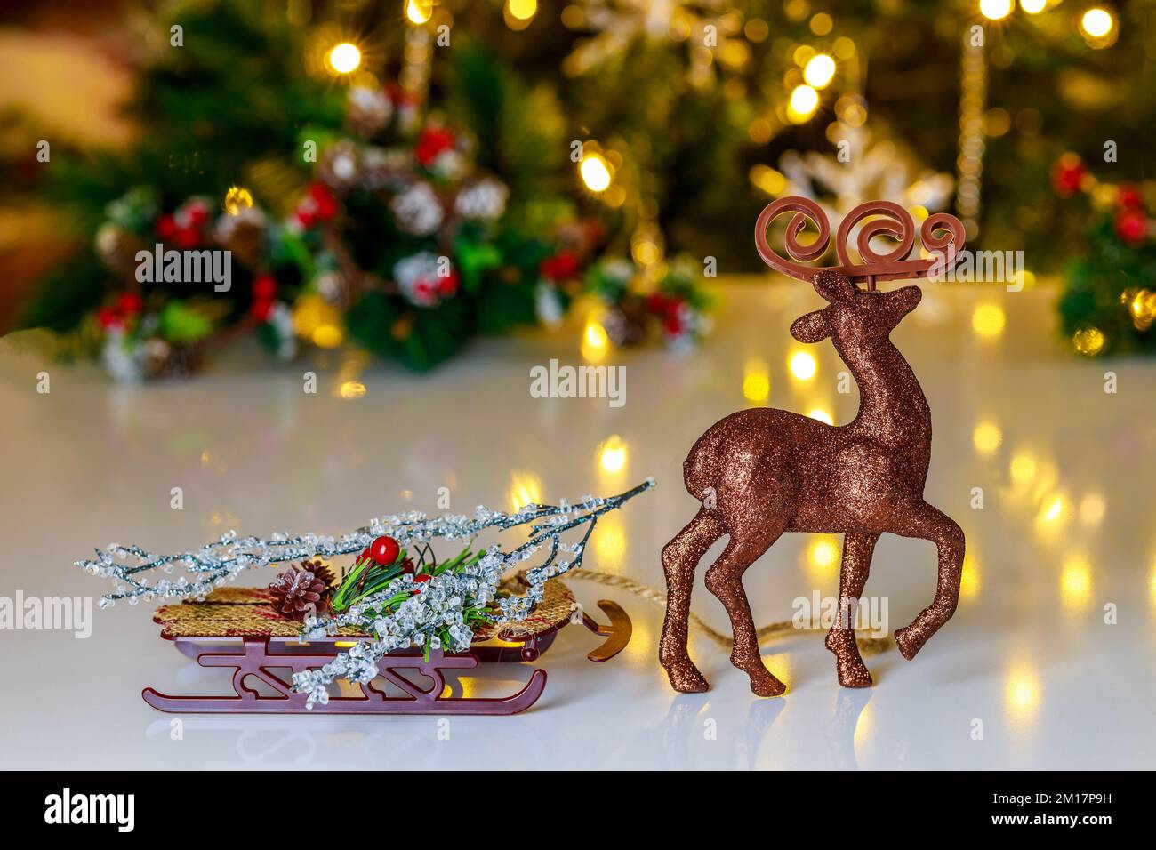 Raindeer-Spielzeug mit Schlitten im Weihnachtshintergrund. Stockfoto