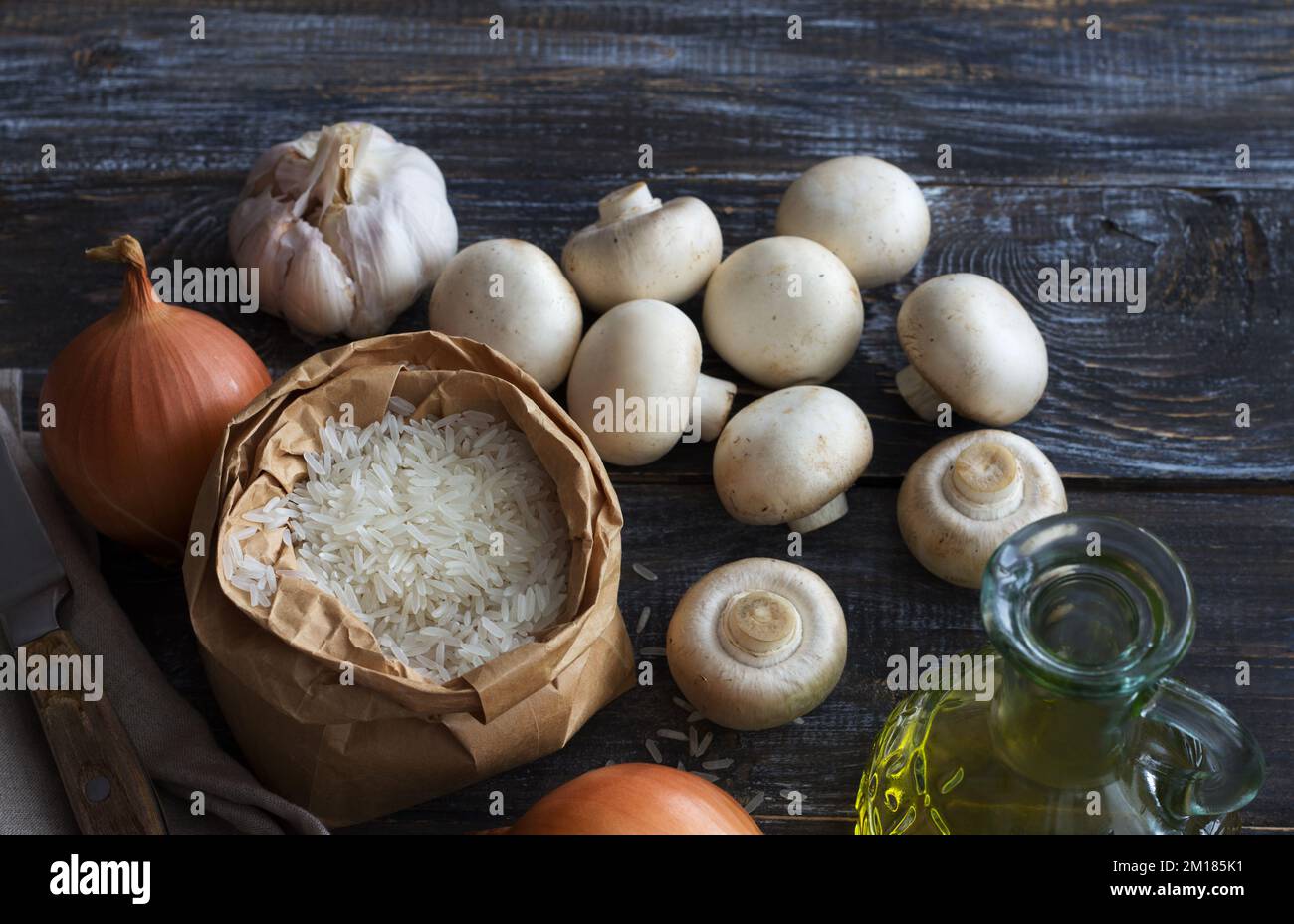 Zutaten für köstliches veganes Gericht. Weißer Basmati-Reis, Knoblauch und Champignons auf einem Holztisch, Draufsicht, Platz, horizontal Stockfoto